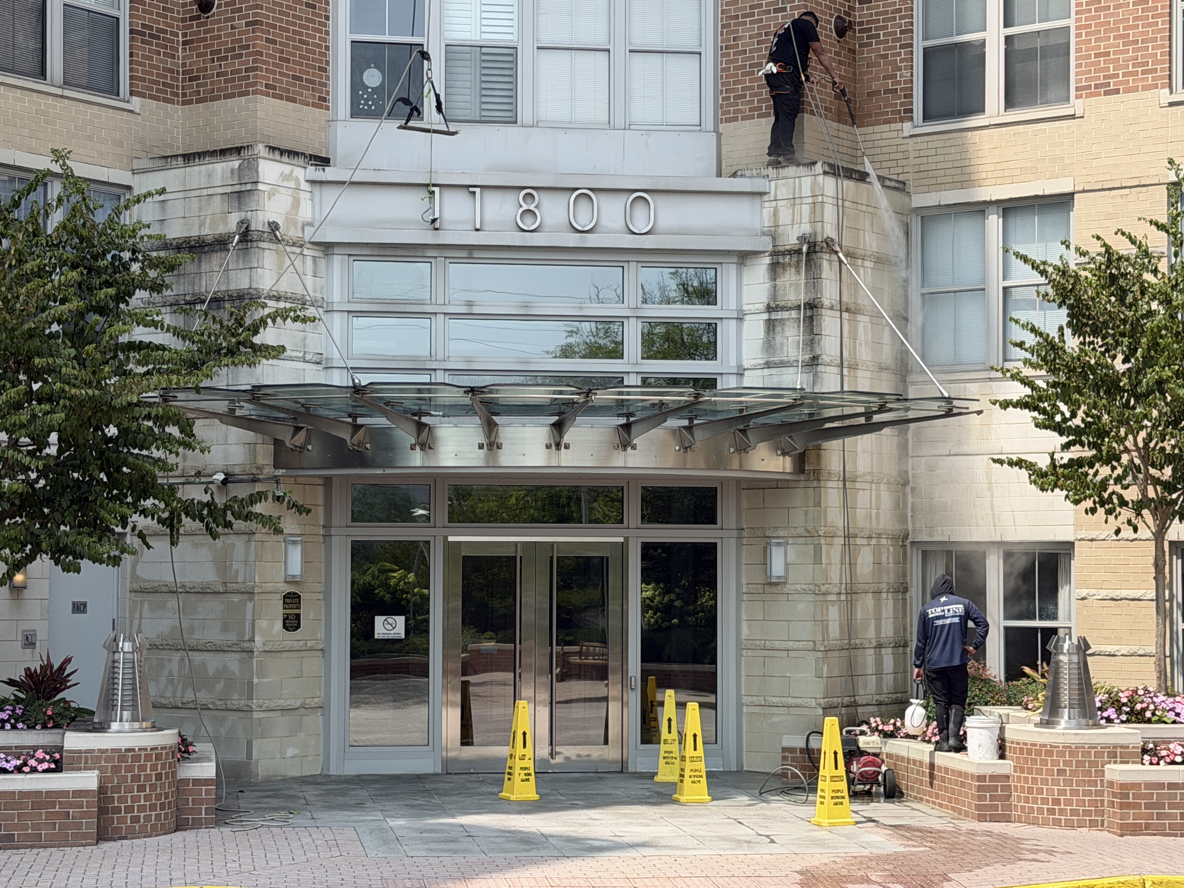 Commercial building facade cleaning at entrance canopy
