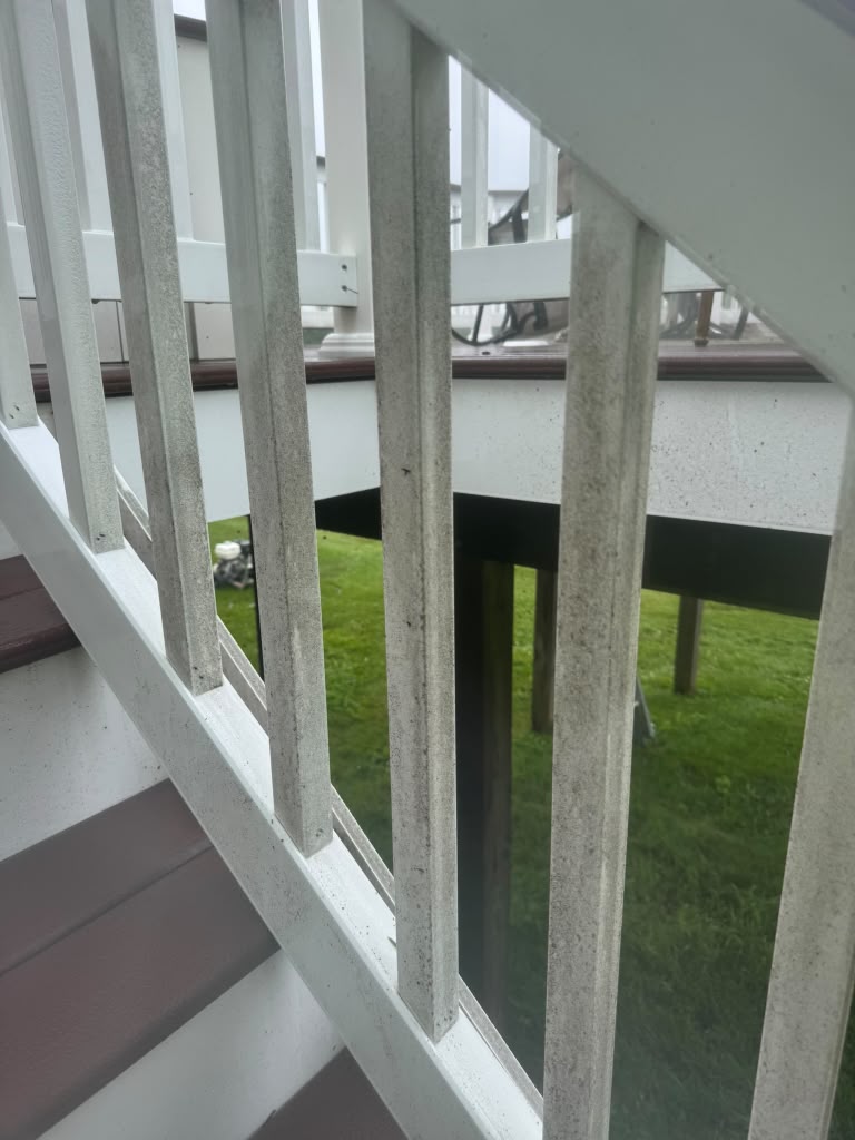White residential deck railing with visible buildup before cleaning in Maryland.