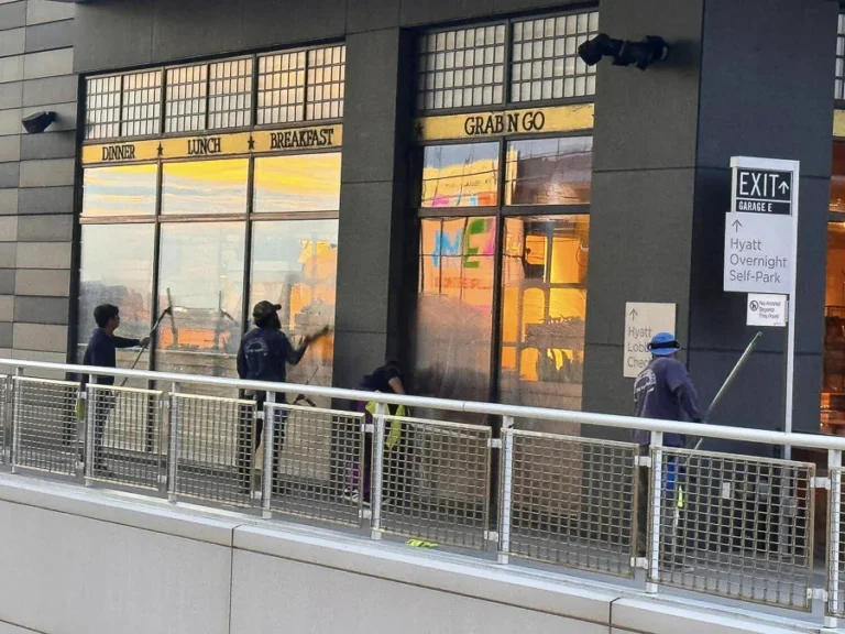Technician cleaning exterior windows on a commercial building