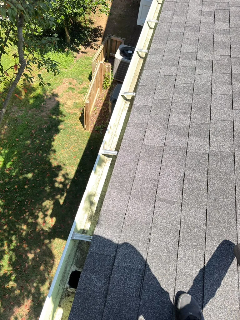 Clean gutter running along a shingled residential roof