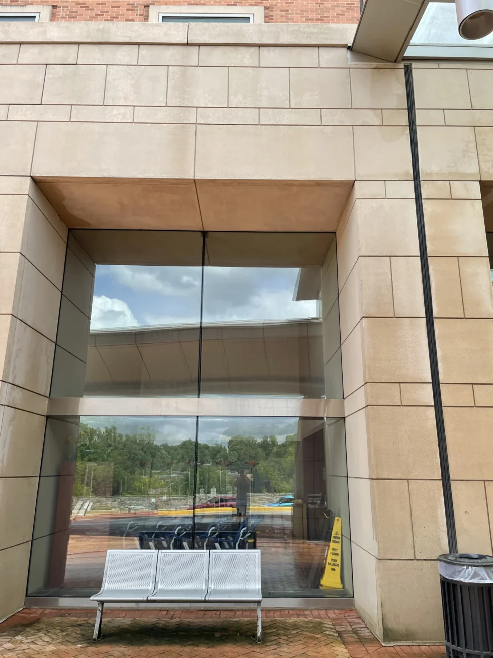 Technician cleaning the exterior stonework around a building entrance