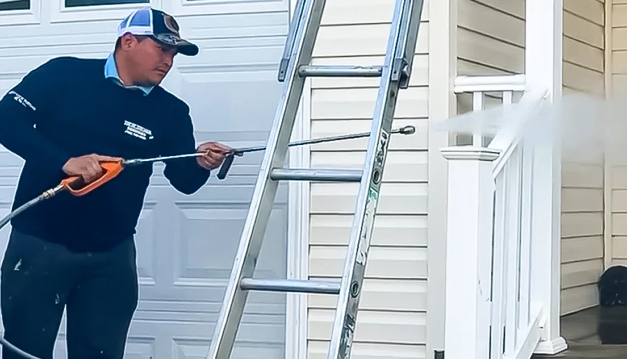 Top of the Line technician washing a residential porch railing
